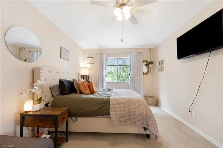 Carpeted bedroom with lofted ceiling and a ceiling fan