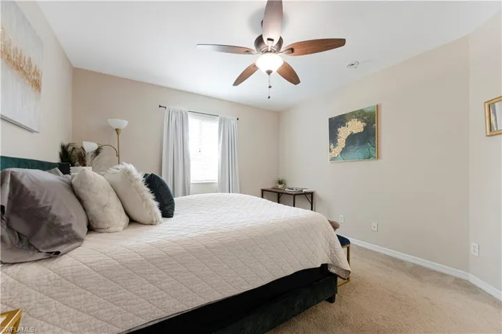 Bedroom featuring light carpet and ceiling fan