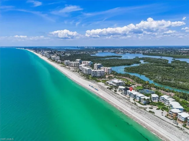 Coastal property featuring direct beach access, proximity to inland waterways, multiple residential buildings, and surrounding natural landscapes