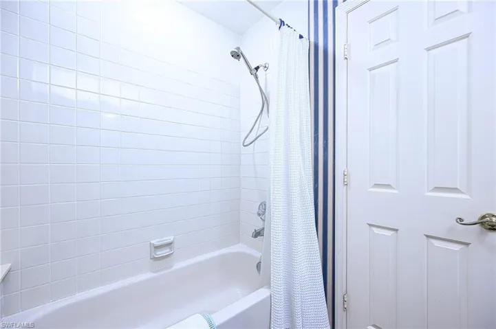 Bathroom featuring shower / bathtub combination with curtain