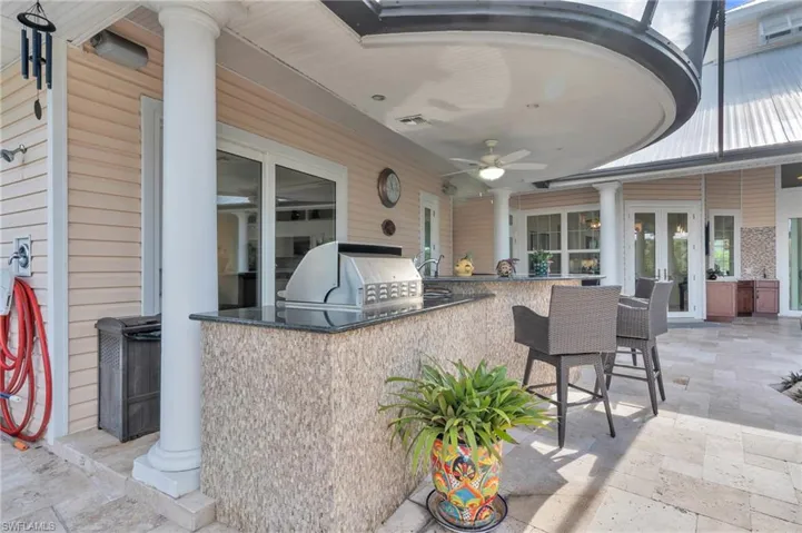 View of patio with an outdoor kitchen, an outdoor bar, and ceiling fan
