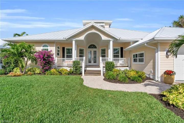 Single story home featuring covered porch and a front yard