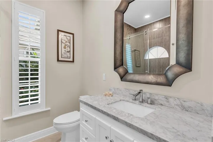 Bathroom with vanity, toilet, and a shower with door