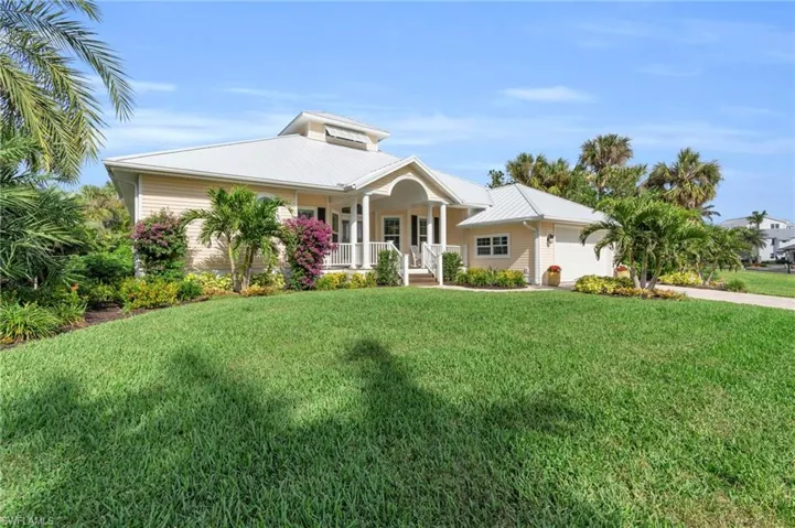View of front of property with a front yard, a porch, and a garage