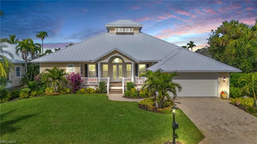 View of front of house featuring a yard, covered porch, french doors, and a garage