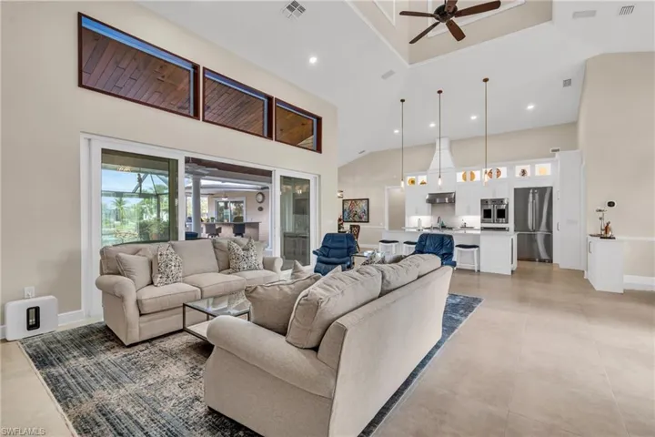 Living room featuring a towering ceiling and ceiling fan