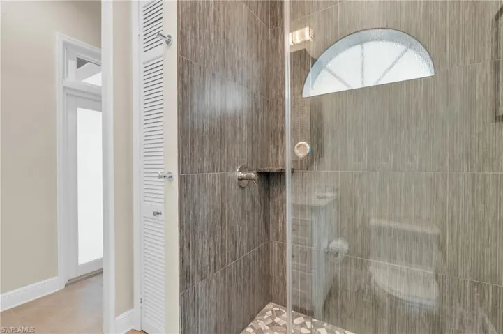 Bathroom featuring tile patterned floors and a shower with door