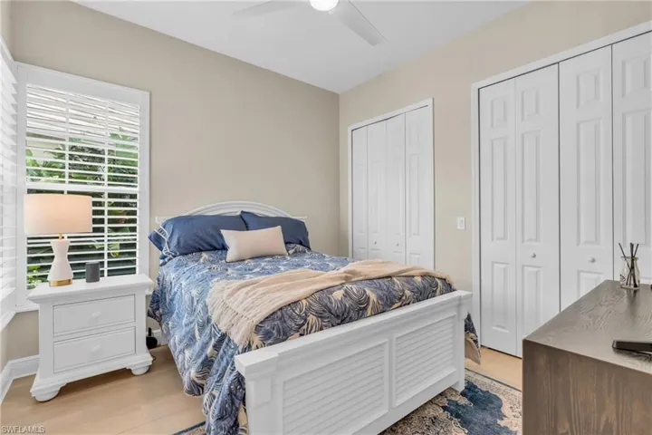 Bedroom with ceiling fan, two closets, and light wood-type flooring