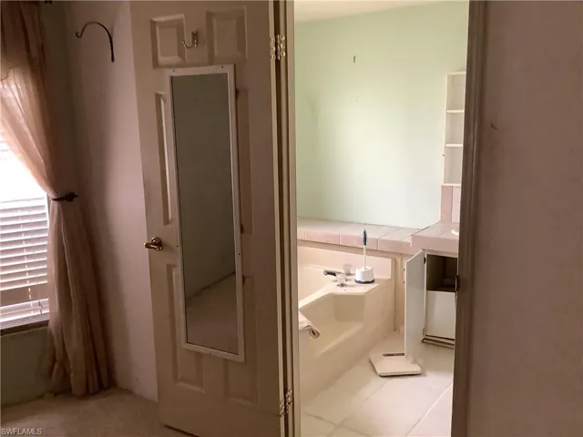 Bathroom featuring a garden tub and tile patterned floors