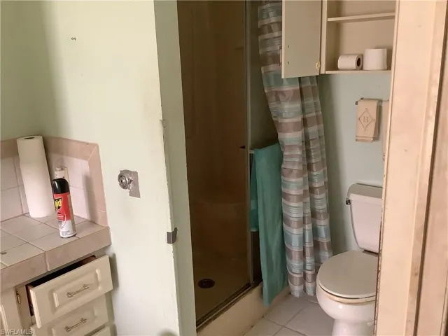 Bathroom with a stall shower and tile patterned flooring