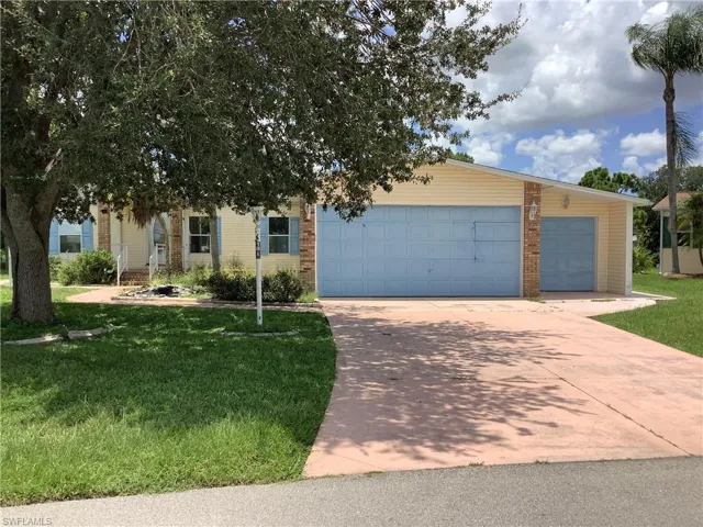 View of front of house featuring a front lawn, brick siding, and concrete driveway