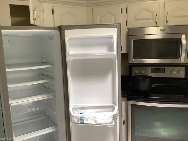 Kitchen view of stainless steel appliances and white cabinets