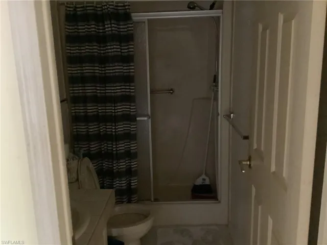 Full bath with a shower with curtain, vanity, and tile patterned flooring