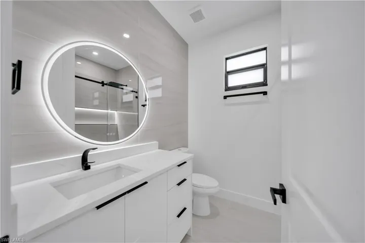 Full bathroom with vanity and a shower stall