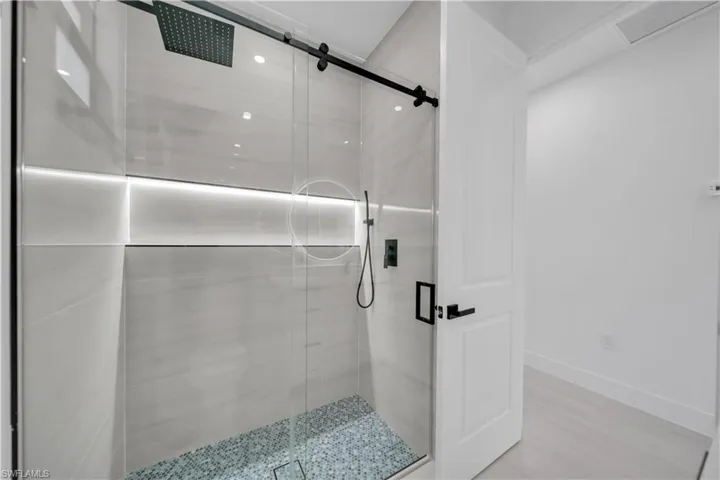 Bathroom with a shower stall and baseboards