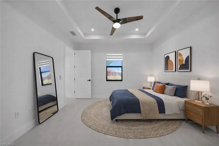 Bedroom featuring ceiling fan, a raised ceiling, and recessed lighting