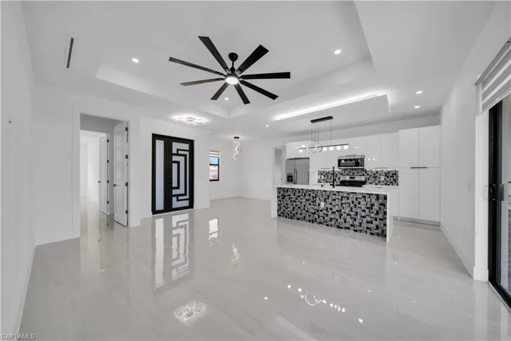 Living room featuring ceiling fan, recessed lighting, and a raised ceiling