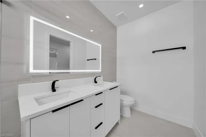 Full bathroom with double vanity and recessed lighting