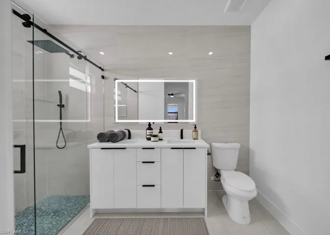 Bathroom featuring double vanity and a stall shower