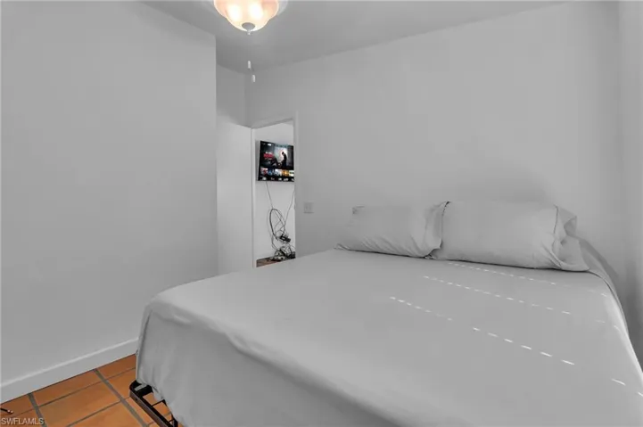 Bedroom featuring light tile patterned flooring and baseboards