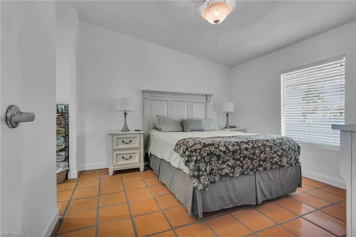 Tiled bedroom featuring baseboards