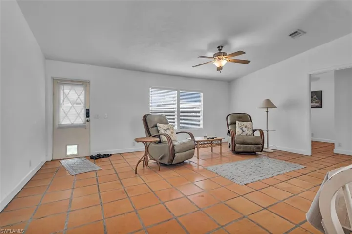 Sitting room with a healthy amount of sunlight, light tile patterned floors, ceiling fan, and visible vents