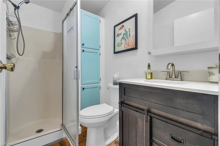 Full bath with toilet, a shower stall, and vanity