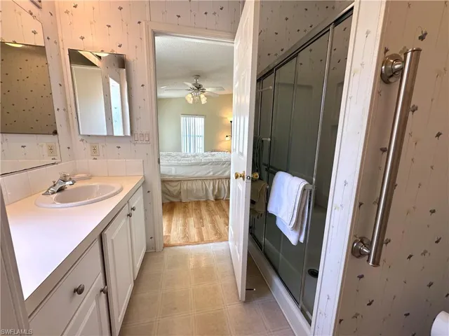 Bathroom featuring an enclosed shower, tile flooring, ceiling fan, and oversized vanity
