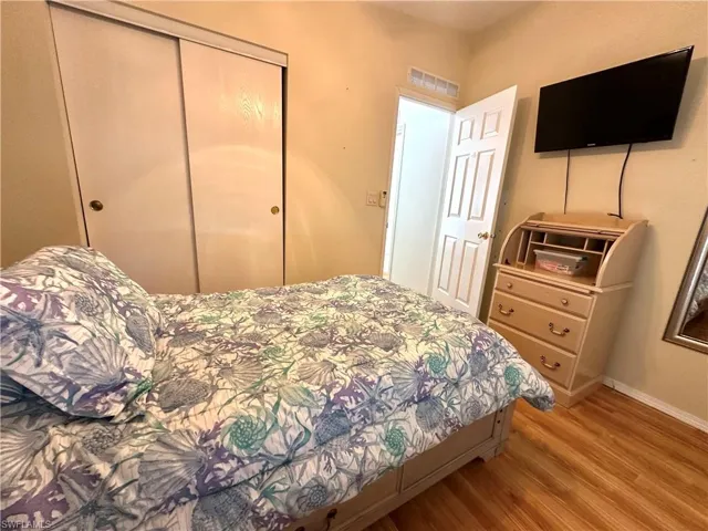 Bedroom with a closet and light hardwood / wood-style floors