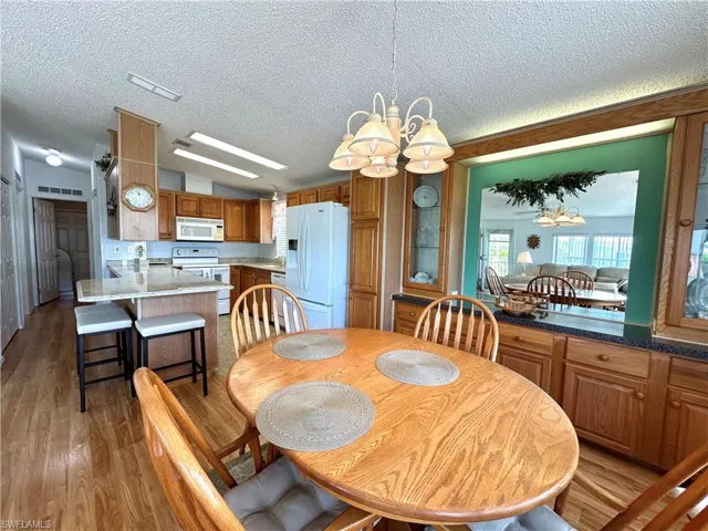 Dining area featuring a notable chandelier, a textured ceiling, and wood-type flooring