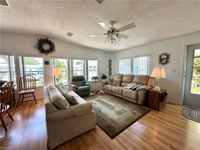 Living room with plenty of natural light, ceiling fan, and hardwood / wood-style flooring
