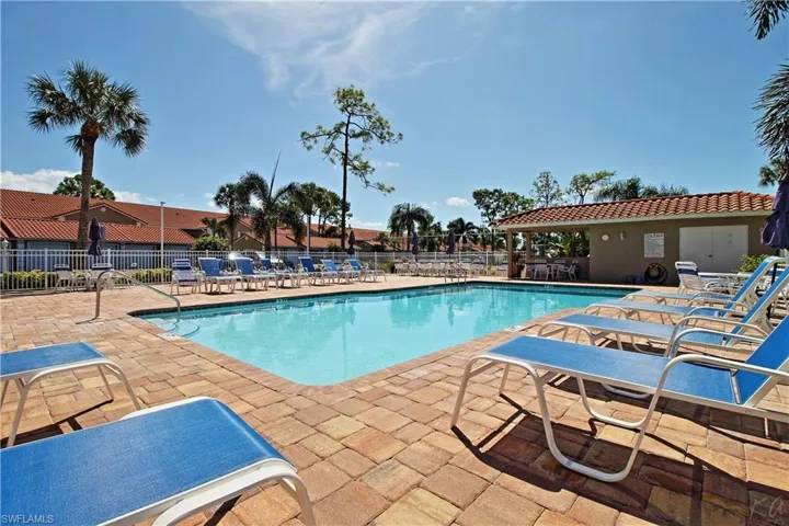 Cobblestone pool with expanded paver brick deck and lots of chaise lounges for sunbathing.