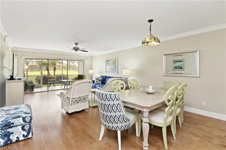 Open and airy great room with crown molding and easy to care for engineered hardwood flooring  with warm, rich color.