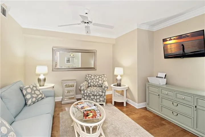 Den with hide-a-bed, pocket doors for privacy, crown molding and wood like tile floor.