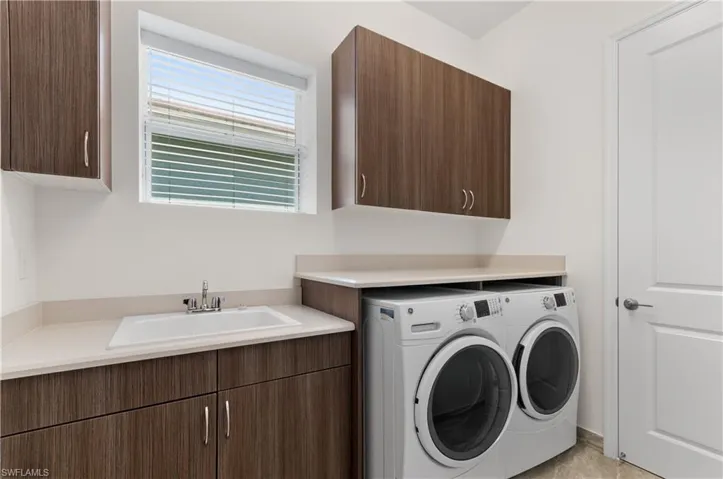 Laundry room with sink,  washer, dryer, and cabinets