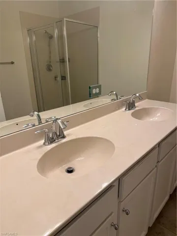 Full bath with a stall shower and double vanity