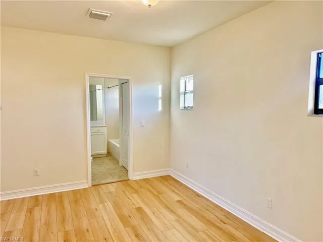 Unfurnished room with light wood-style flooring and baseboards
