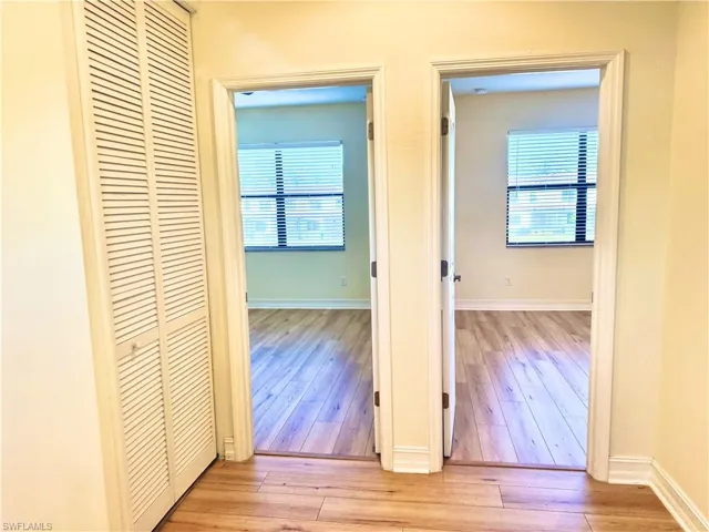 Hallway featuring light wood finished floors and healthy amount of natural light