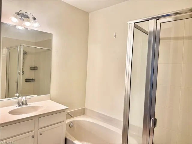 Bathroom featuring vanity, a garden tub, and a shower stall