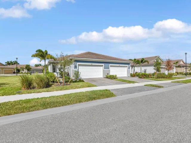 Beautiful Villa featuring a front and side yard and a 2 car garage