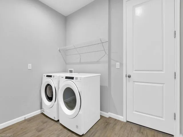 Clothes washing area featuring hardwood / wood-style flooring and separate washer and dryer