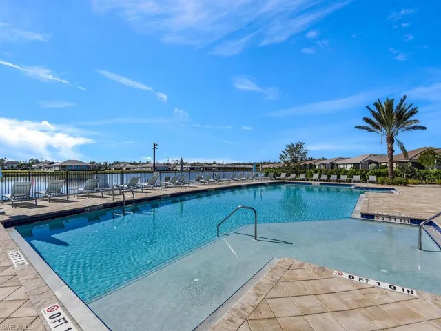 View of swimming pool with a water view and a patio