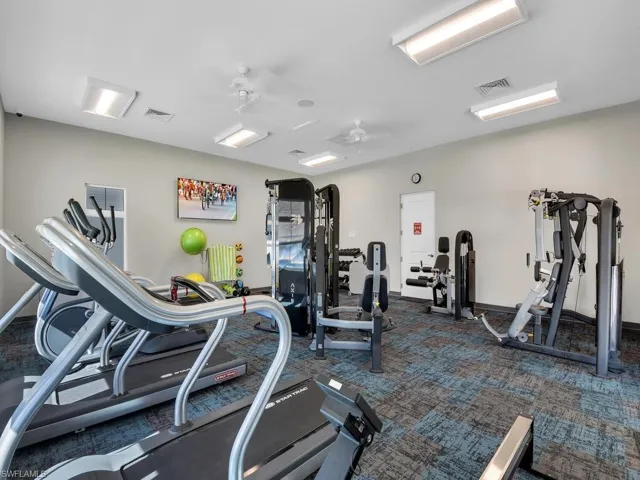 Gym with dark carpet and ceiling fan