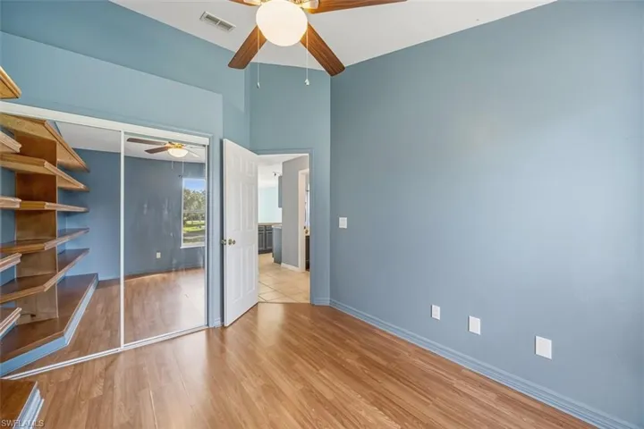 Unfurnished bedroom with wood finished floors, ceiling fan, and a closet