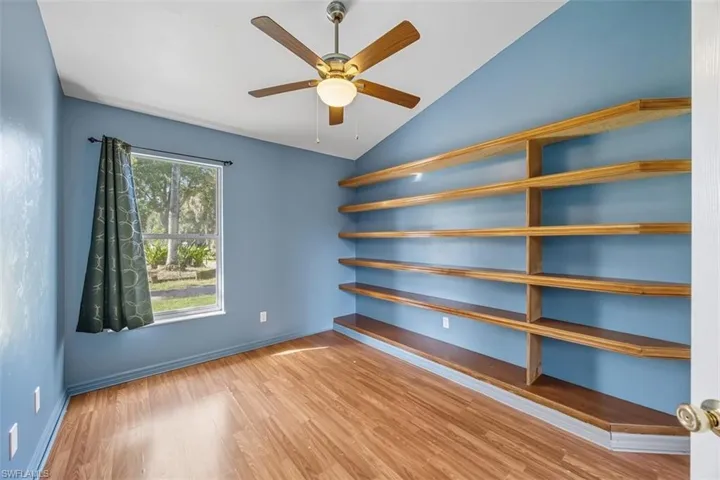 Unfurnished office with light wood finished floors, lofted ceiling, and ceiling fan