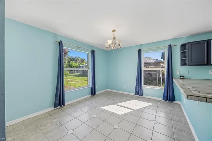 Unfurnished dining area featuring light tile patterned floors and a chandelier