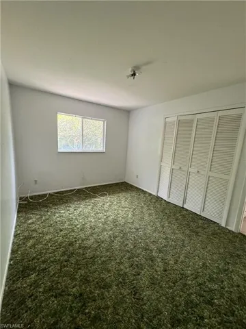 Unfurnished bedroom with carpet and a closet