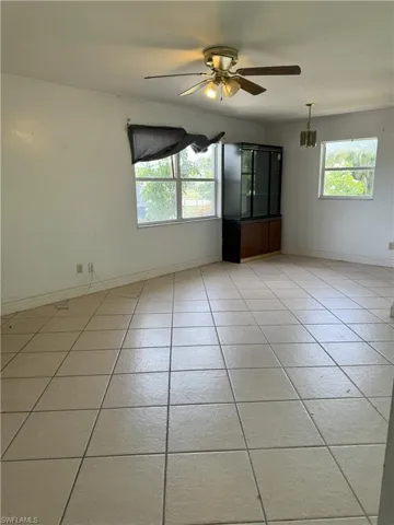 Tiled empty room featuring ceiling fan