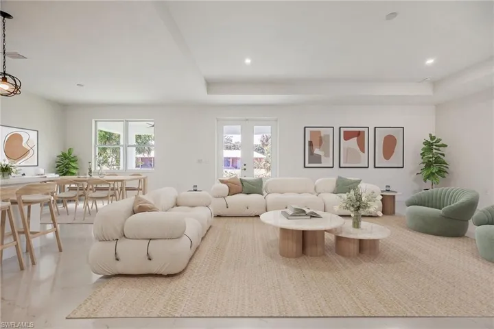 Living area with recessed lighting, french doors, and a raised ceiling