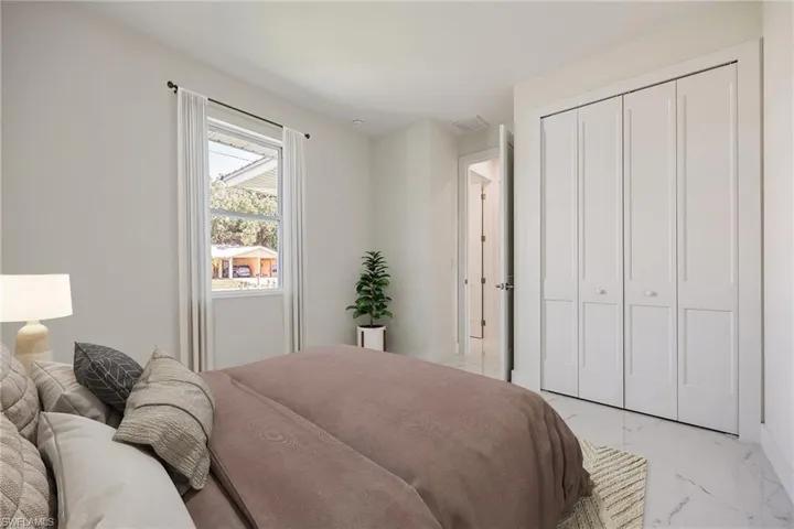 Bedroom featuring visible vents, marble finish floor, and a closet